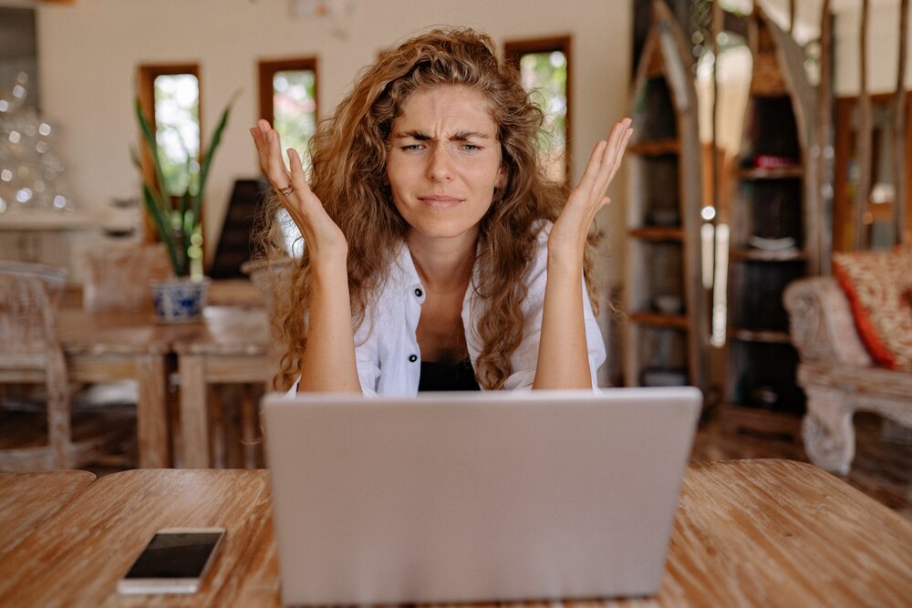 Afbeelding - vrouw achter laptop heeft frustratie