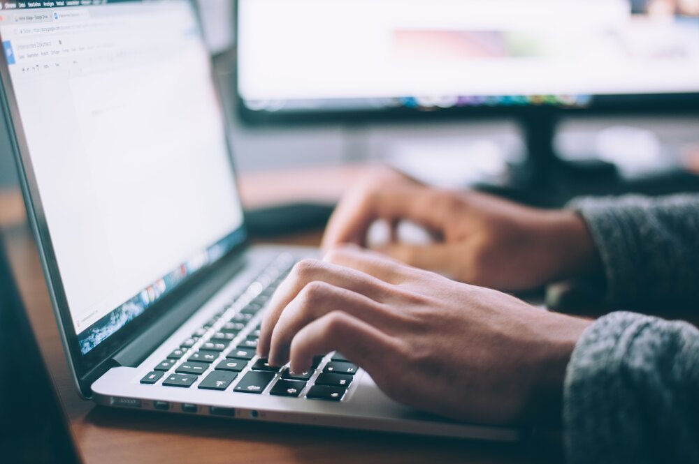 Werkende achter laptop